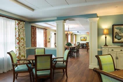 A well-lit dining area with wooden floors and elegant furniture.