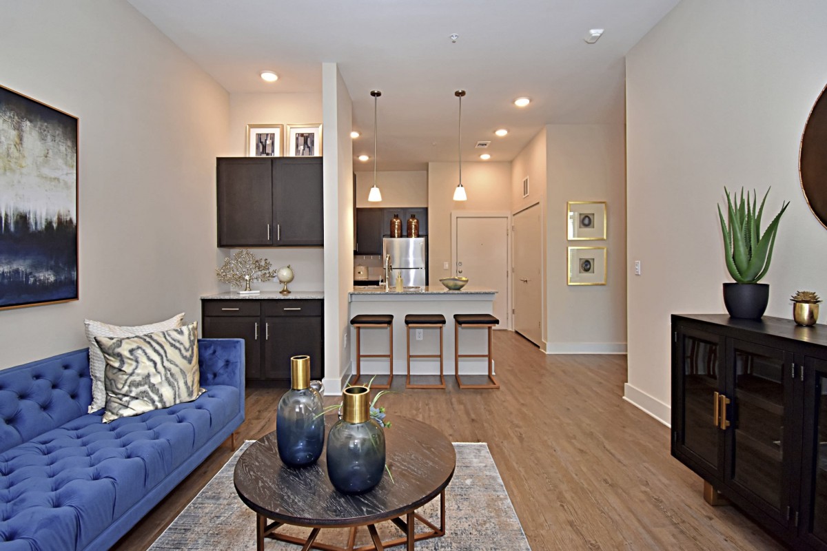 A modern open-concept living room and kitchen with stylish decor and hardwood floors.