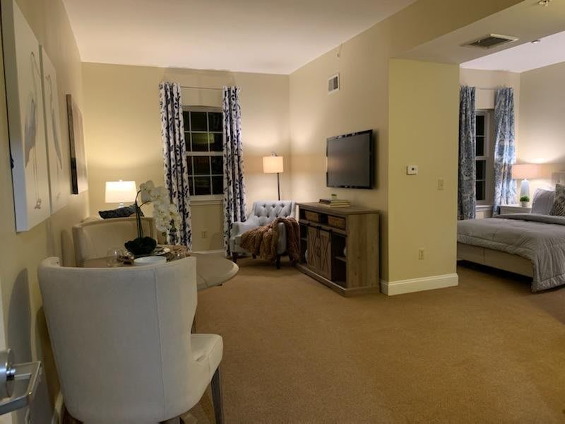 A cozy living room with comfortable seating, warm lighting, and a television.