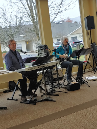 Two musicians performing live at an indoor event.