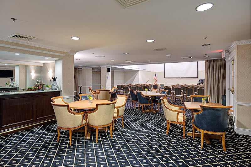 A modern conference room setup with tables and chairs arranged for a meeting or presentation.
