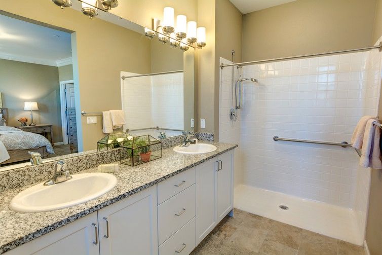 A modern bathroom with double sinks and a spacious shower.