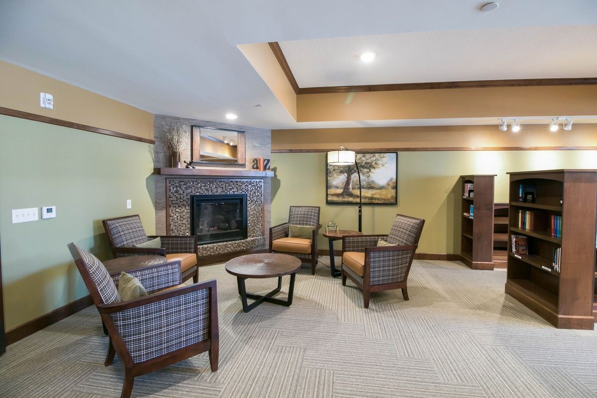 A cozy living room with comfortable seating around a fireplace.