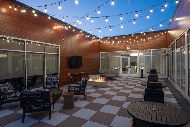 Cozy outdoor patio with string lights and a fire pit.