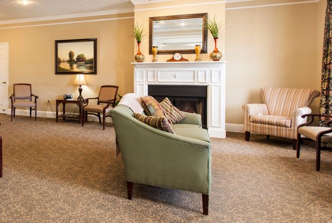 A cozy living room with a fireplace, sofa, and armchair.