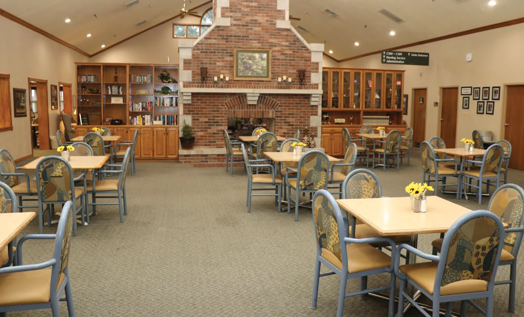 A cozy dining area featuring a brick fireplace and neatly arranged tables and chairs.