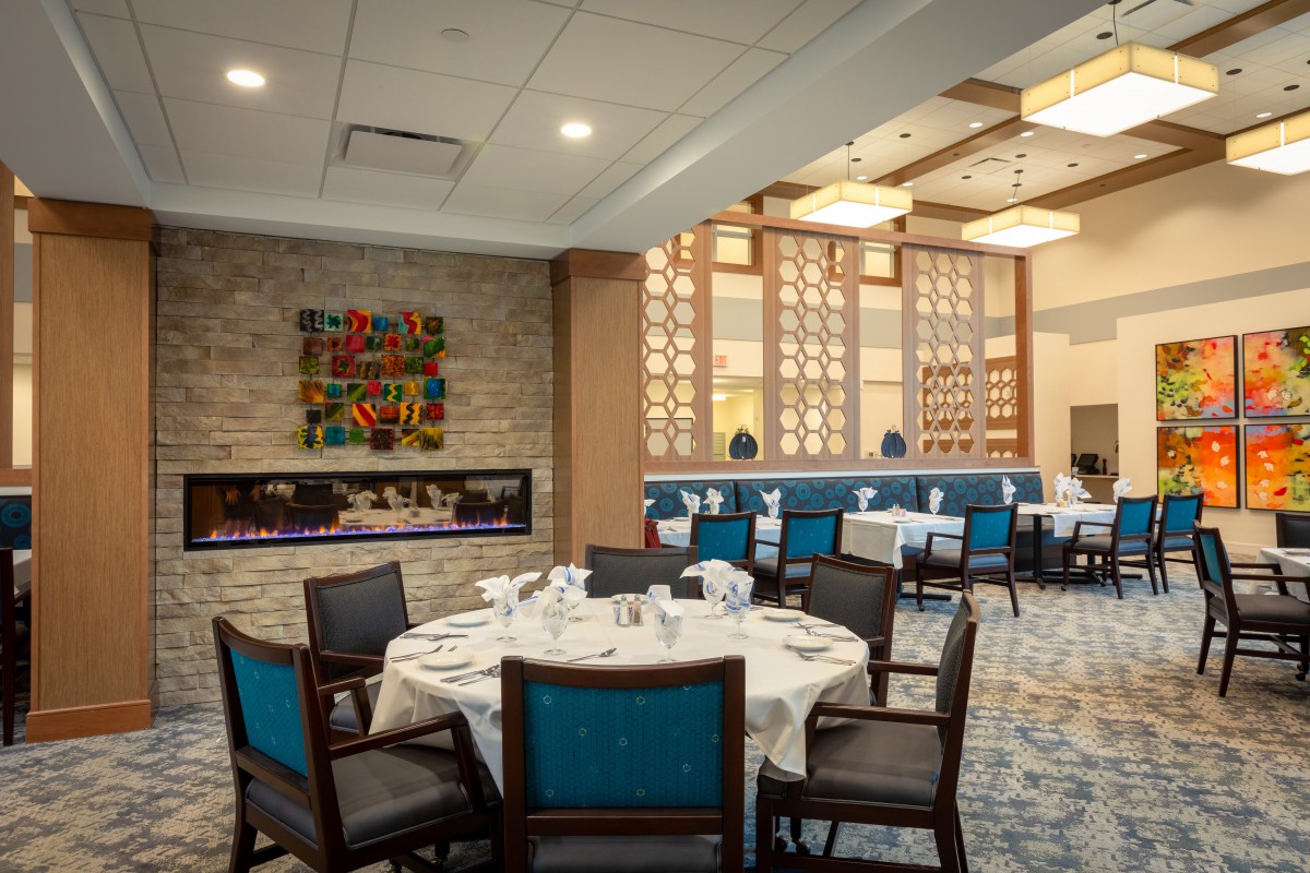 A stylish restaurant dining area with neatly set tables, elegant decor, and warm lighting.