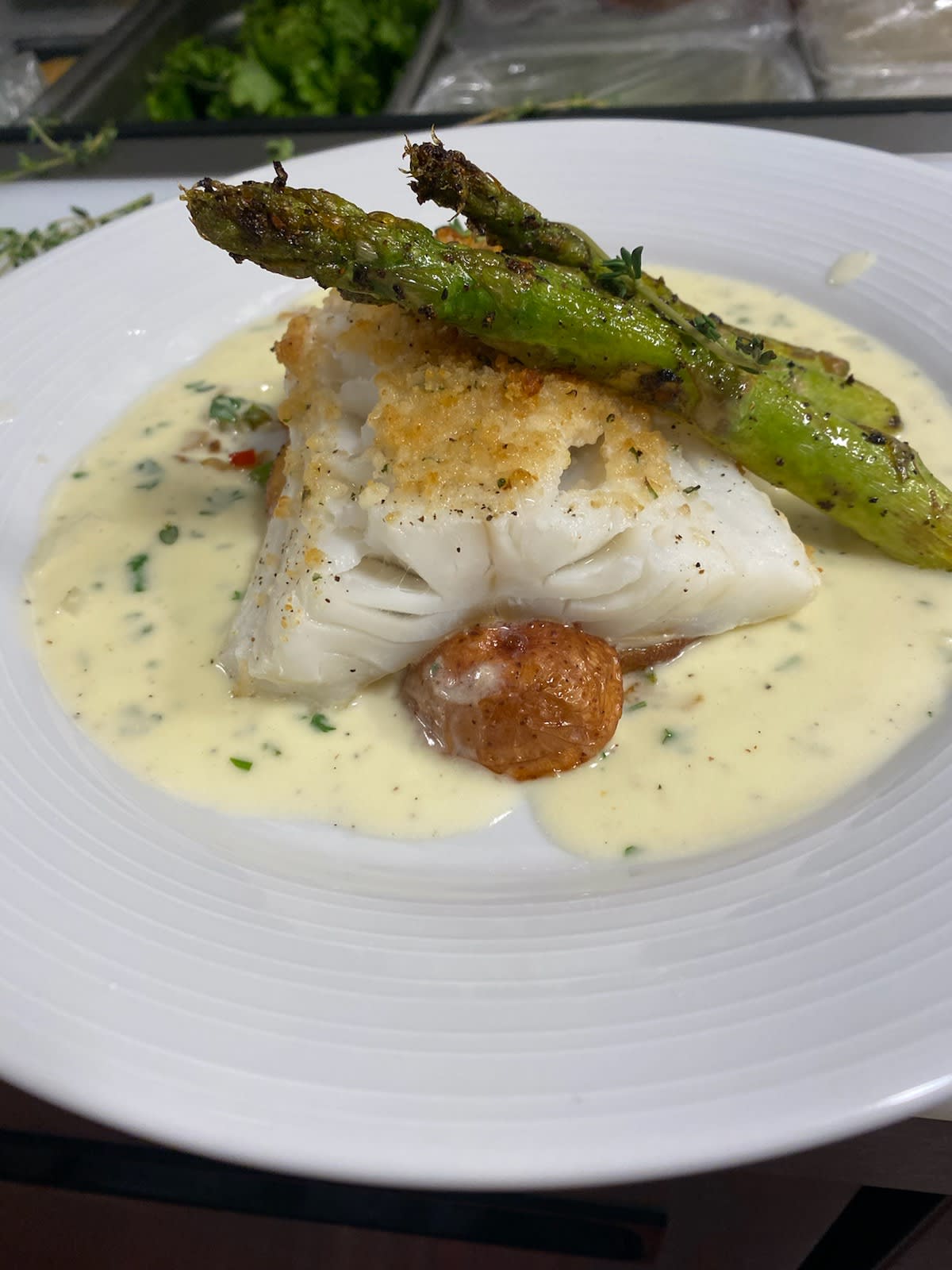 Gourmet fish dish with asparagus and creamy sauce.