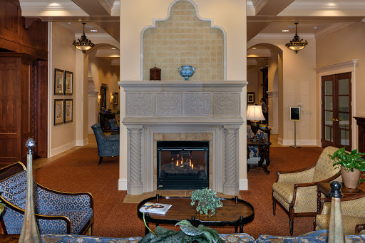 A cozy lounge area featuring a stylish fireplace, comfortable seating, and elegant decor.