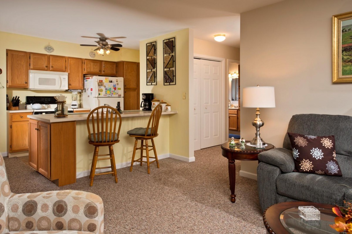 A cozy living area with a view of the kitchen and bar stools.