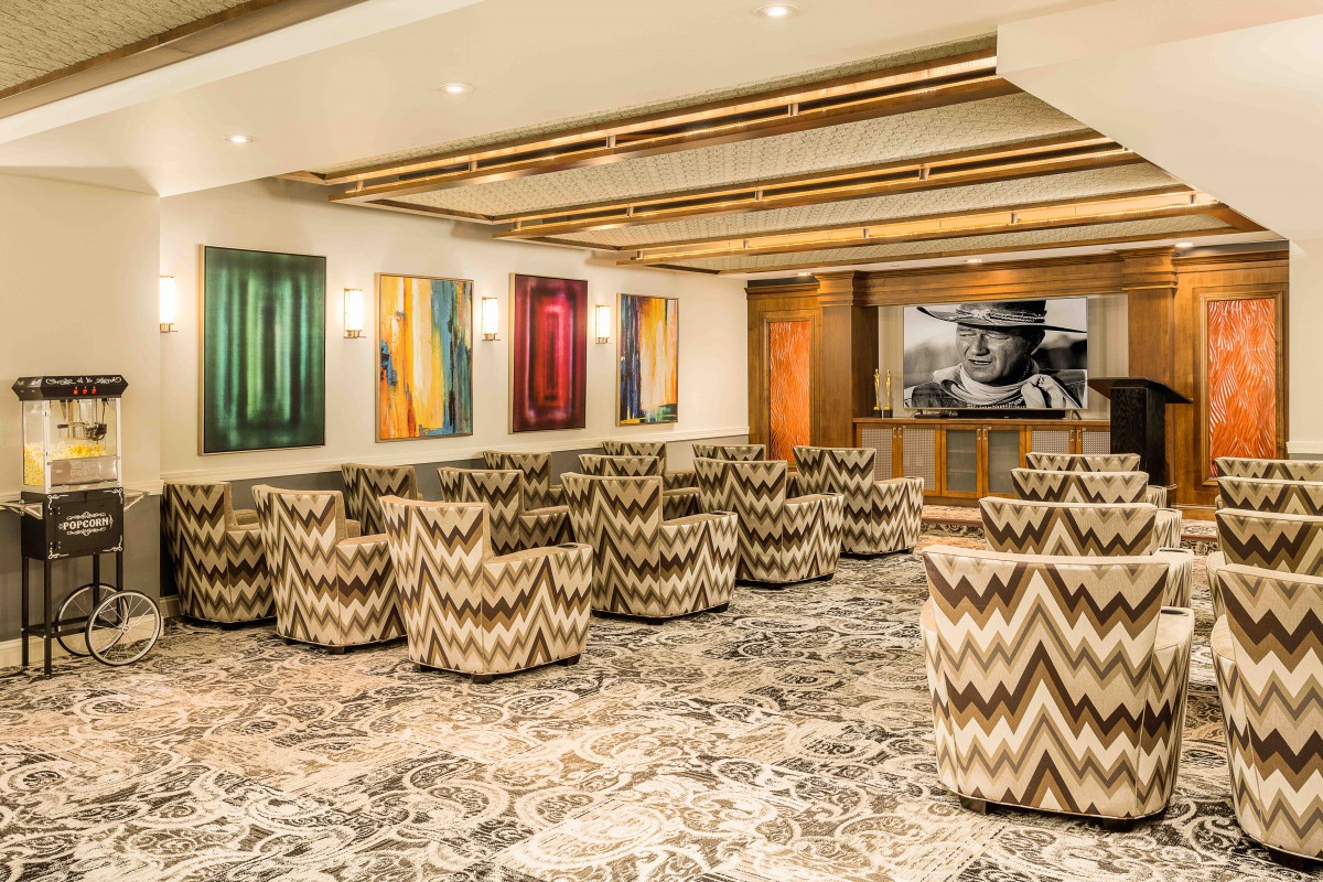 A modern conference room featuring patterned chairs, colorful artwork, and a sophisticated ambiance.