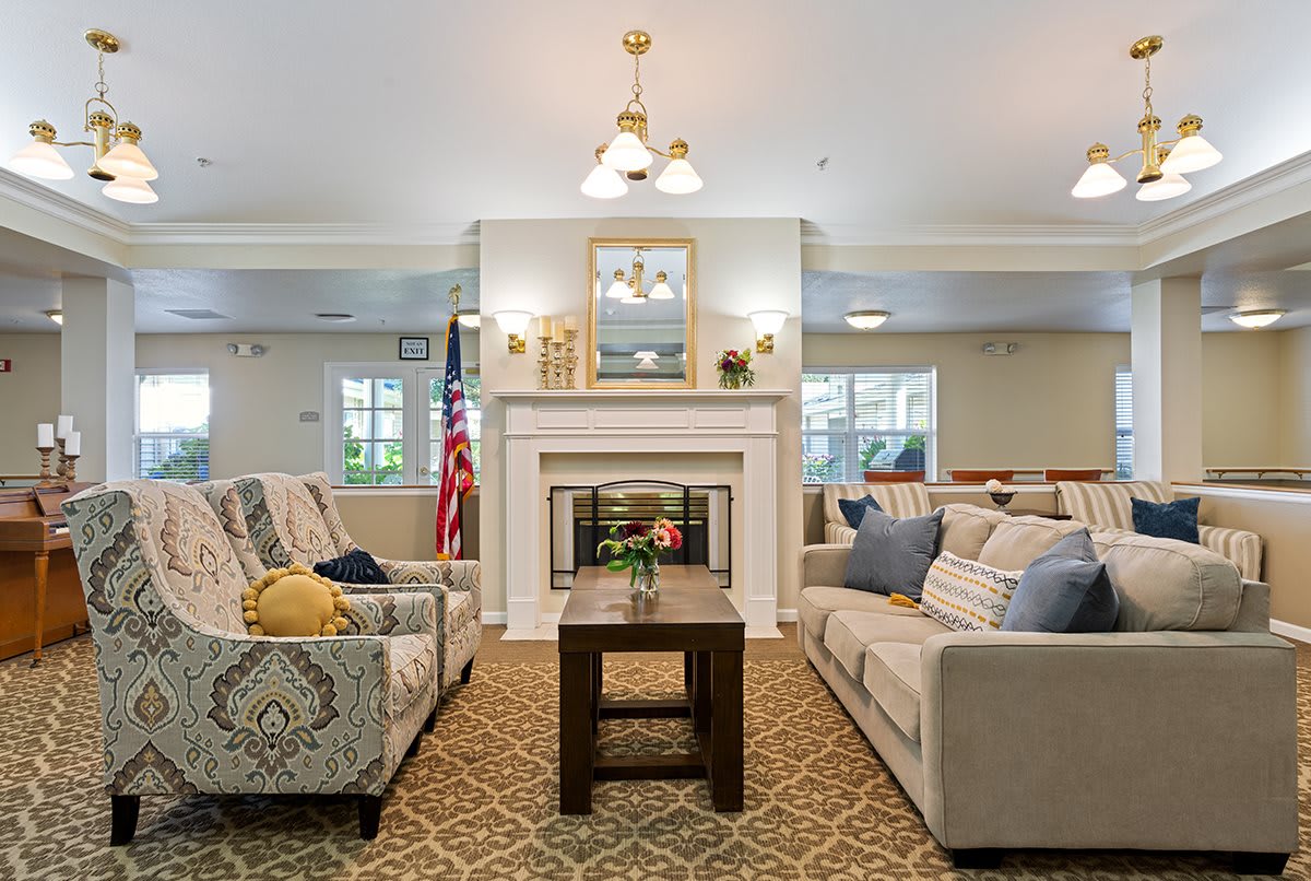 A cozy living room featuring a central fireplace, two sofas, and a wooden coffee table, adorned with comfortable decor and ambient lighting.