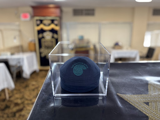 A kippah displayed in a transparent case, highlighting its significance in Jewish tradition.