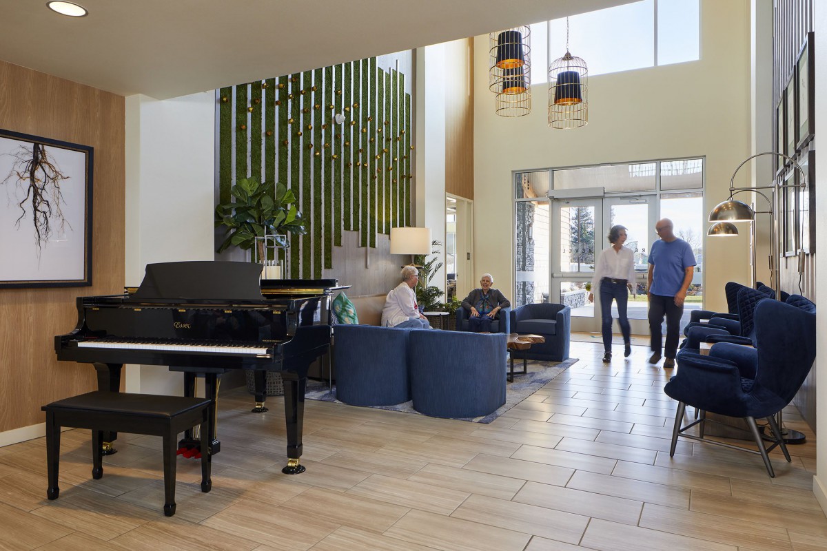 A spacious lobby area features a grand piano, modern seating, and contemporary decor.