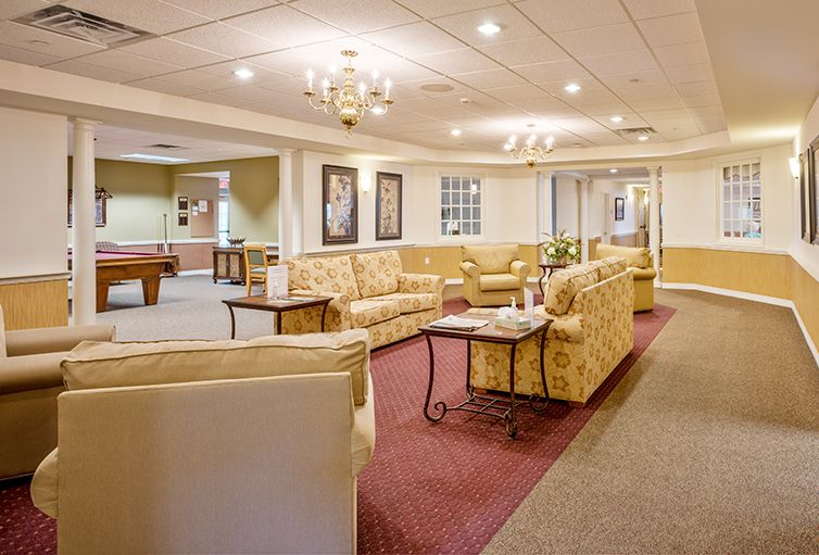 A cozy lobby area with sofas and a chandelier, featuring elegant interior design.