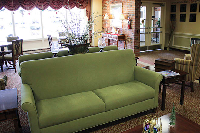 A cozy living room featuring a green sofa with elegant decor.