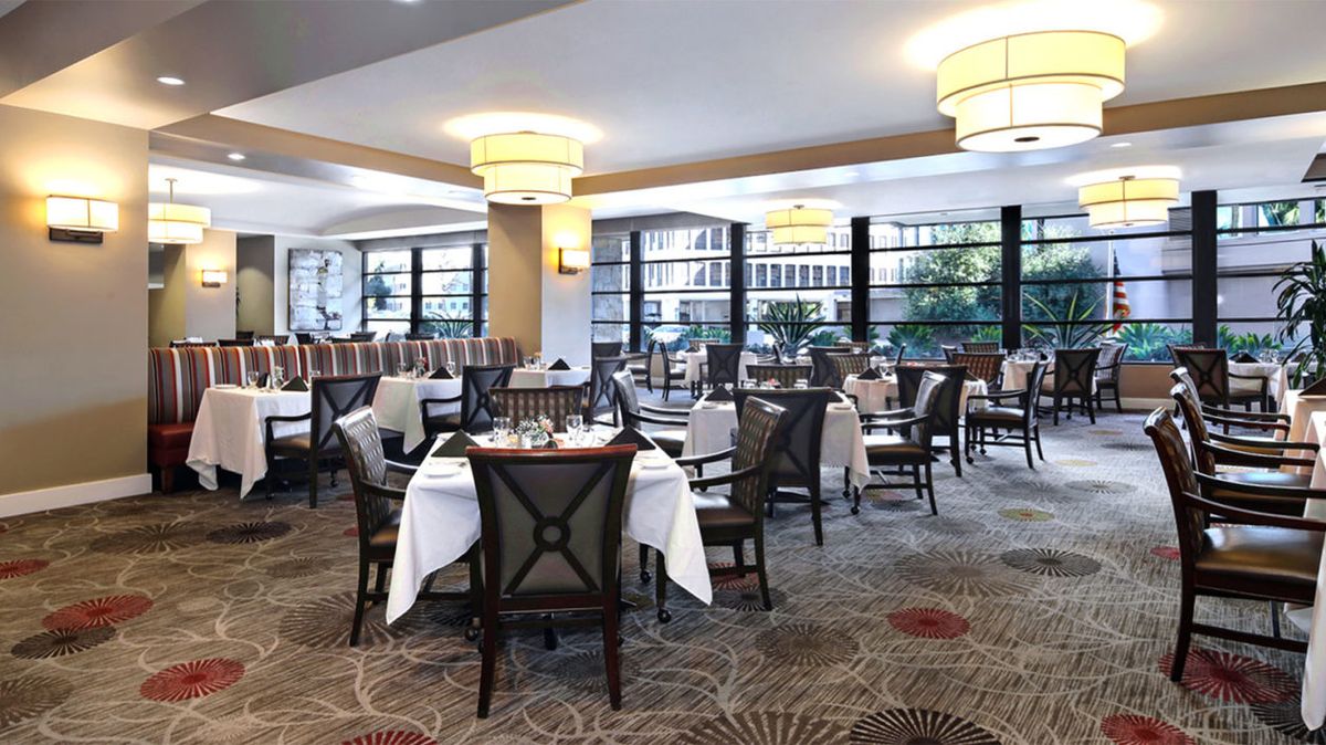 A modern and elegant restaurant dining area with neatly arranged tables and chairs.