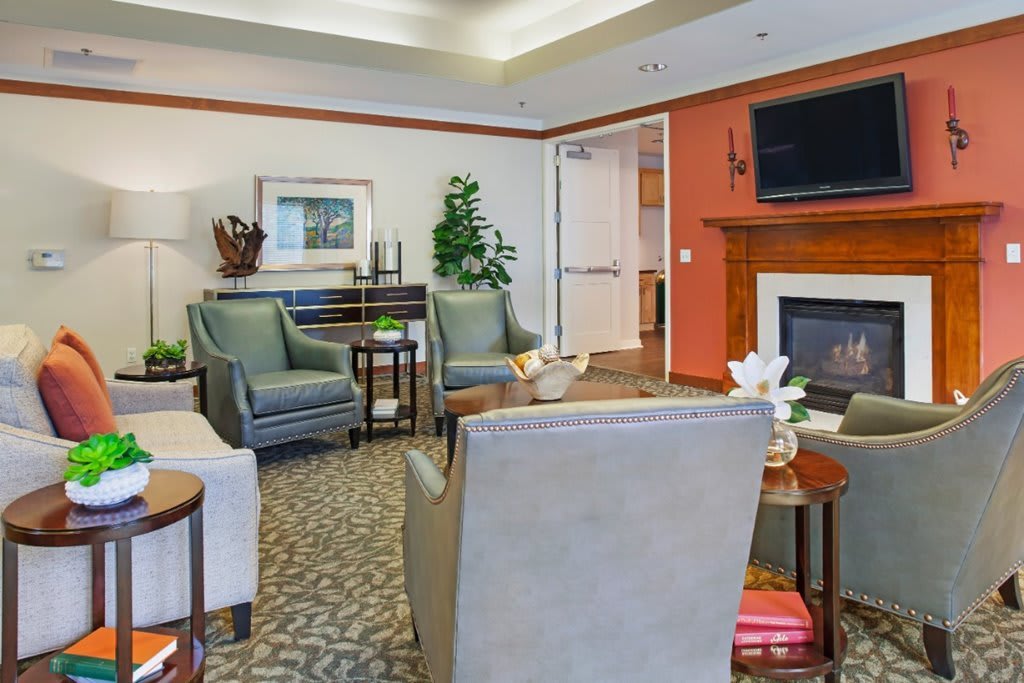 A cozy living room with comfortable seating, a fireplace, and a television.