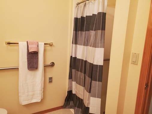 A cozy bathroom with striped shower curtain and neatly hung towels.