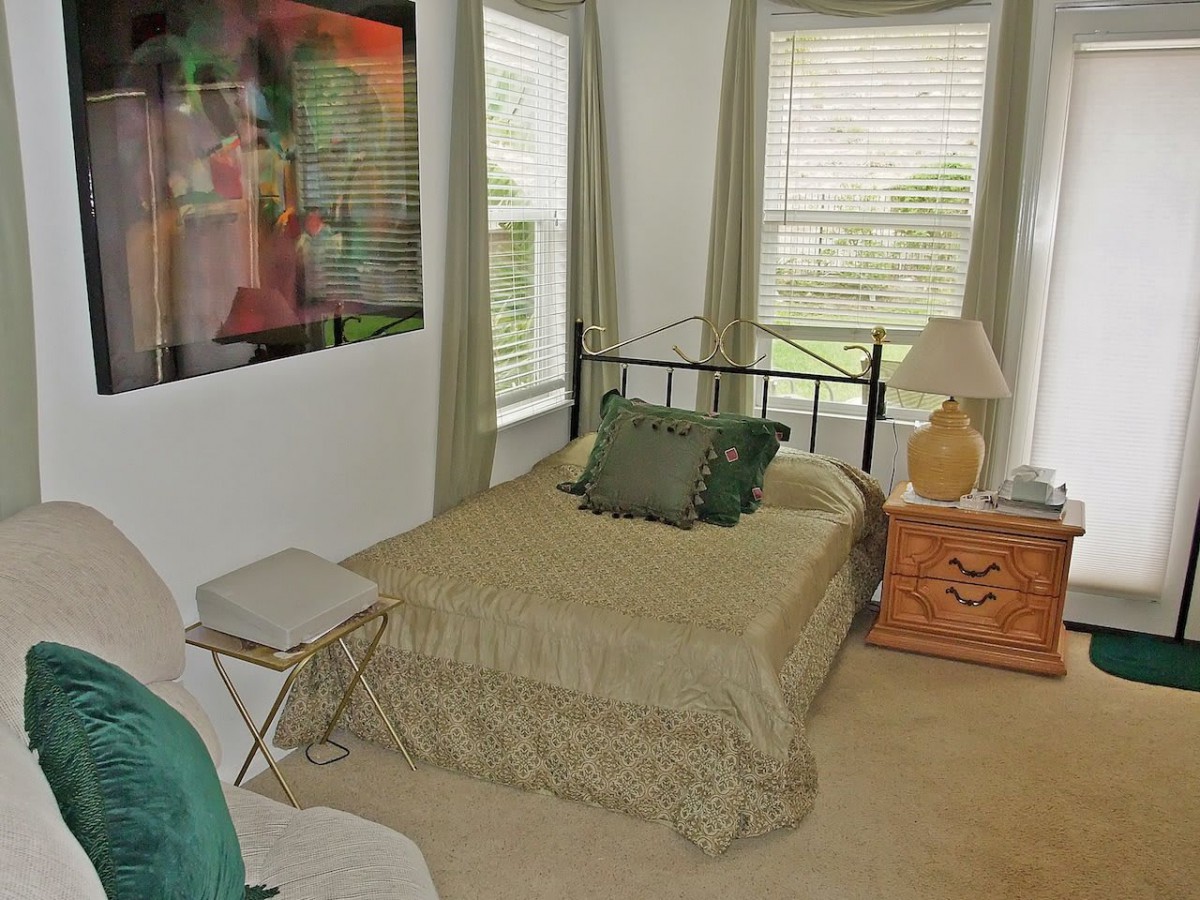 A cozy bedroom with a bed, side table, and decor items.