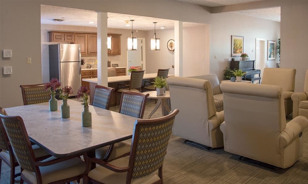 A modern open floor plan featuring a comfortable living room, a dining area with stylish chairs, and a kitchen equipped with stainless steel appliances.