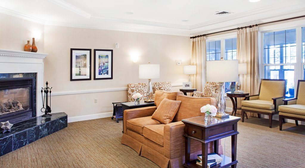 A cozy and elegantly decorated living room with a comfortable sofa, lamps, and framed artwork.