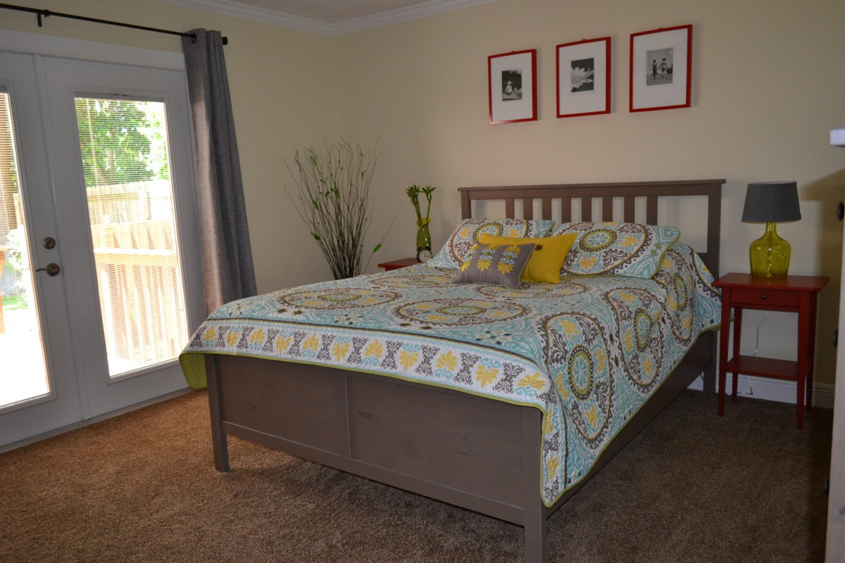 A cozy bedroom with a neatly made bed and decorative pillows.