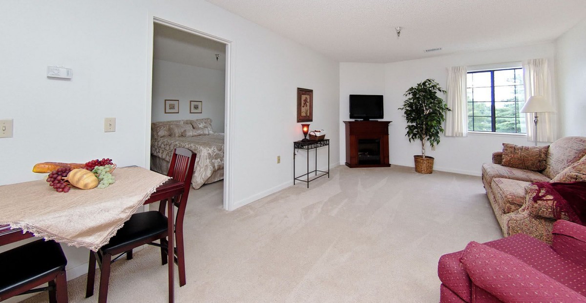 Spacious living area with a view into the bedroom, featuring modern furnishings and decor.