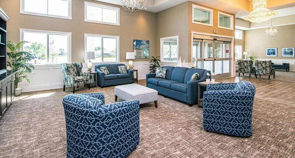 A modern living room with blue sofas and armchairs, a coffee table, and elegant decor.
