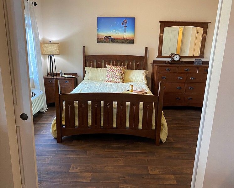 A cozy bedroom with wooden furniture and warm lighting.
