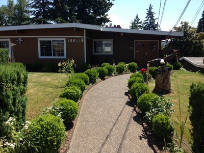 A charming home with a well-kept garden and a winding pathway.