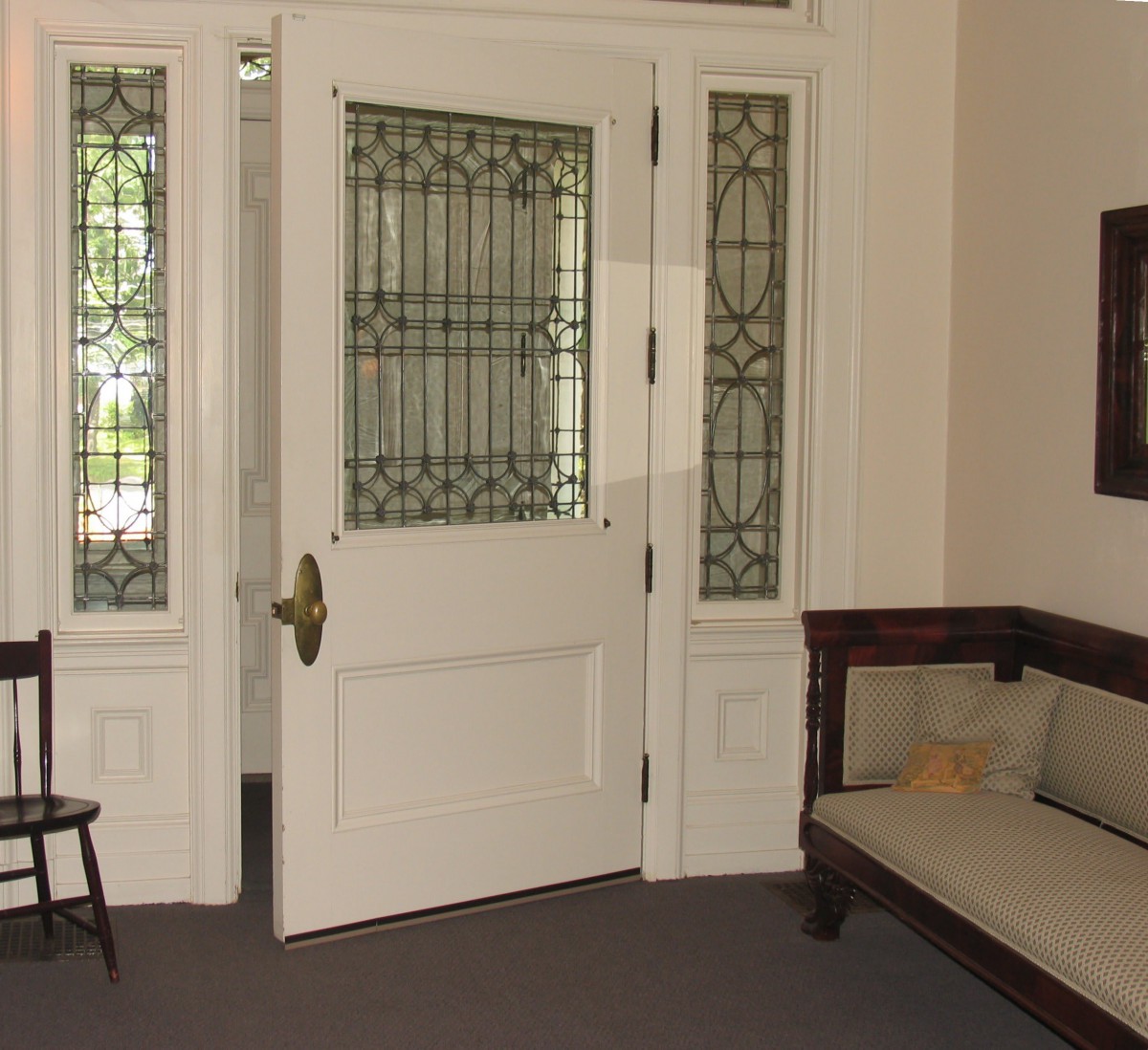 A cozy interior space featuring a decorative door with stained glass and comfortable seating.