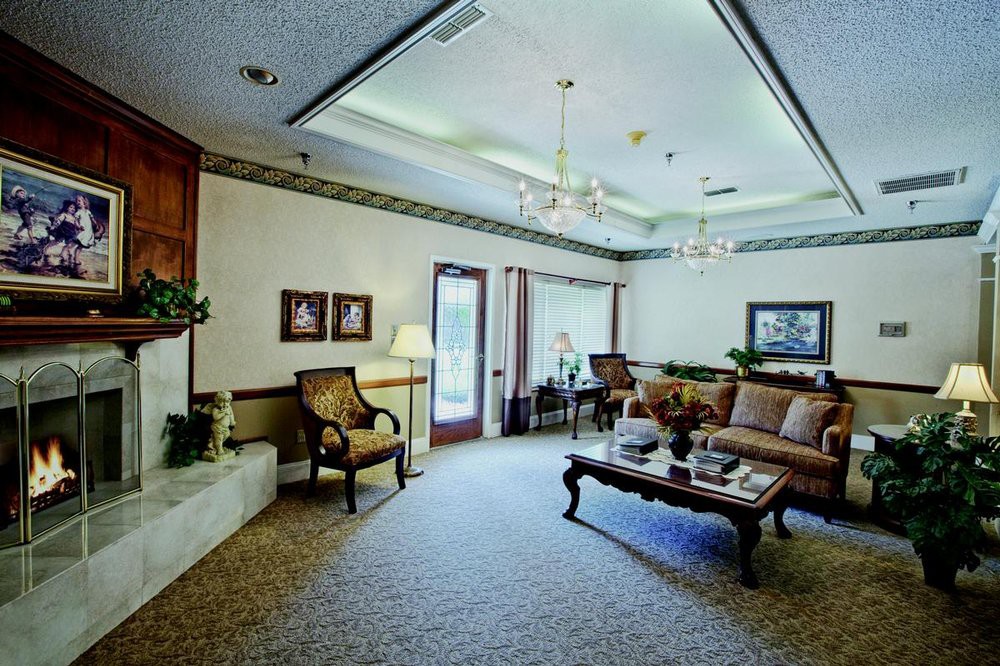 A spacious living room with elegant furnishings and decor, featuring a sofa set, coffee table, and chandelier.