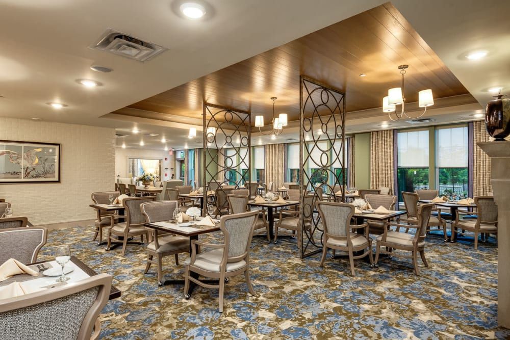 A modern dining area with tables, chairs, and decorative lighting.