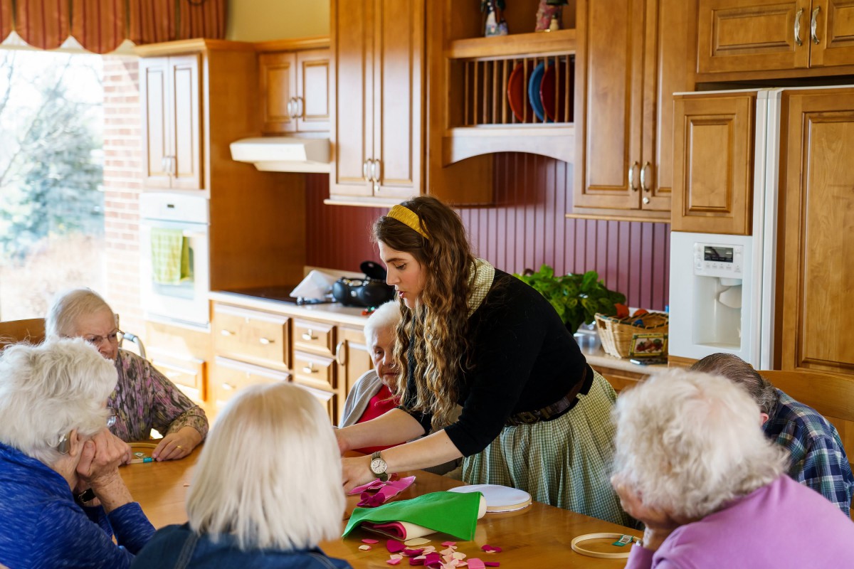 A group of people engaged in a crafting activity in a kitchen setting.