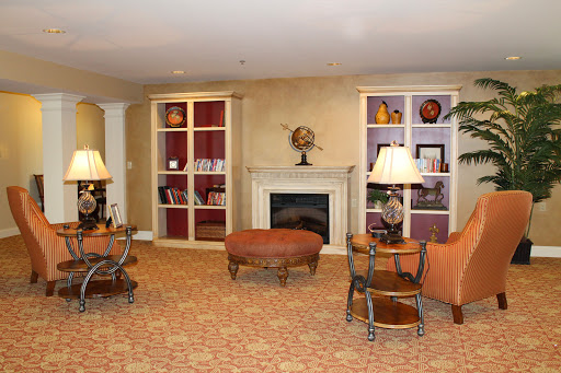 A cozy living room featuring a fireplace, comfortable seating, and decorative shelves.