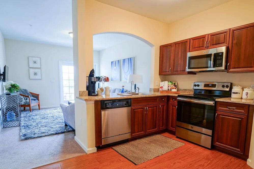 A modern kitchen with stainless steel appliances and wood cabinets.