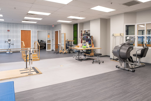 A spacious and modern physical therapy room equipped with various rehabilitation tools.