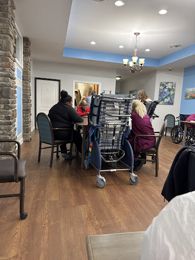 A gathering of individuals at a dining area in an elderly care facility.