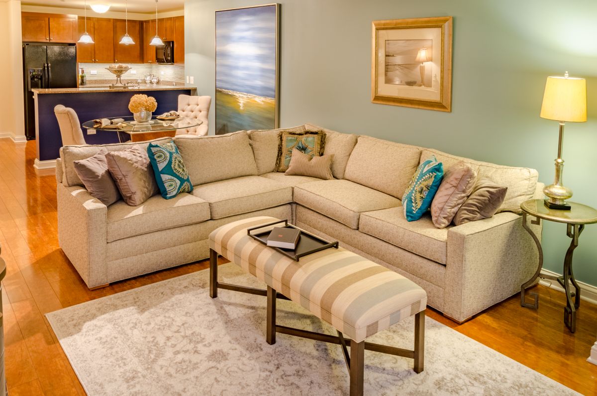 A cozy living room with a beige sectional sofa, colorful pillows, and modern decor.