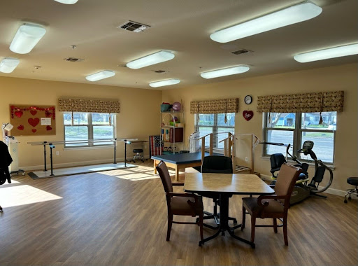 A bright and spacious rehabilitation room equipped for group activities and therapy.