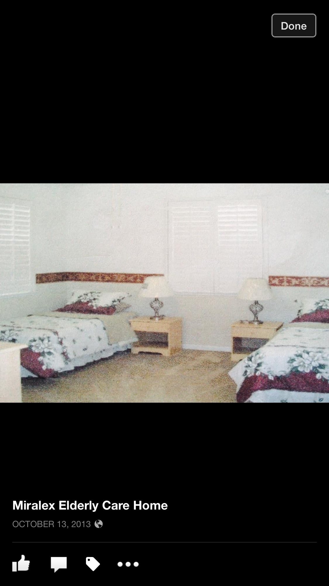 A cozy bedroom featuring twin beds with floral bedding and matching nightstands.