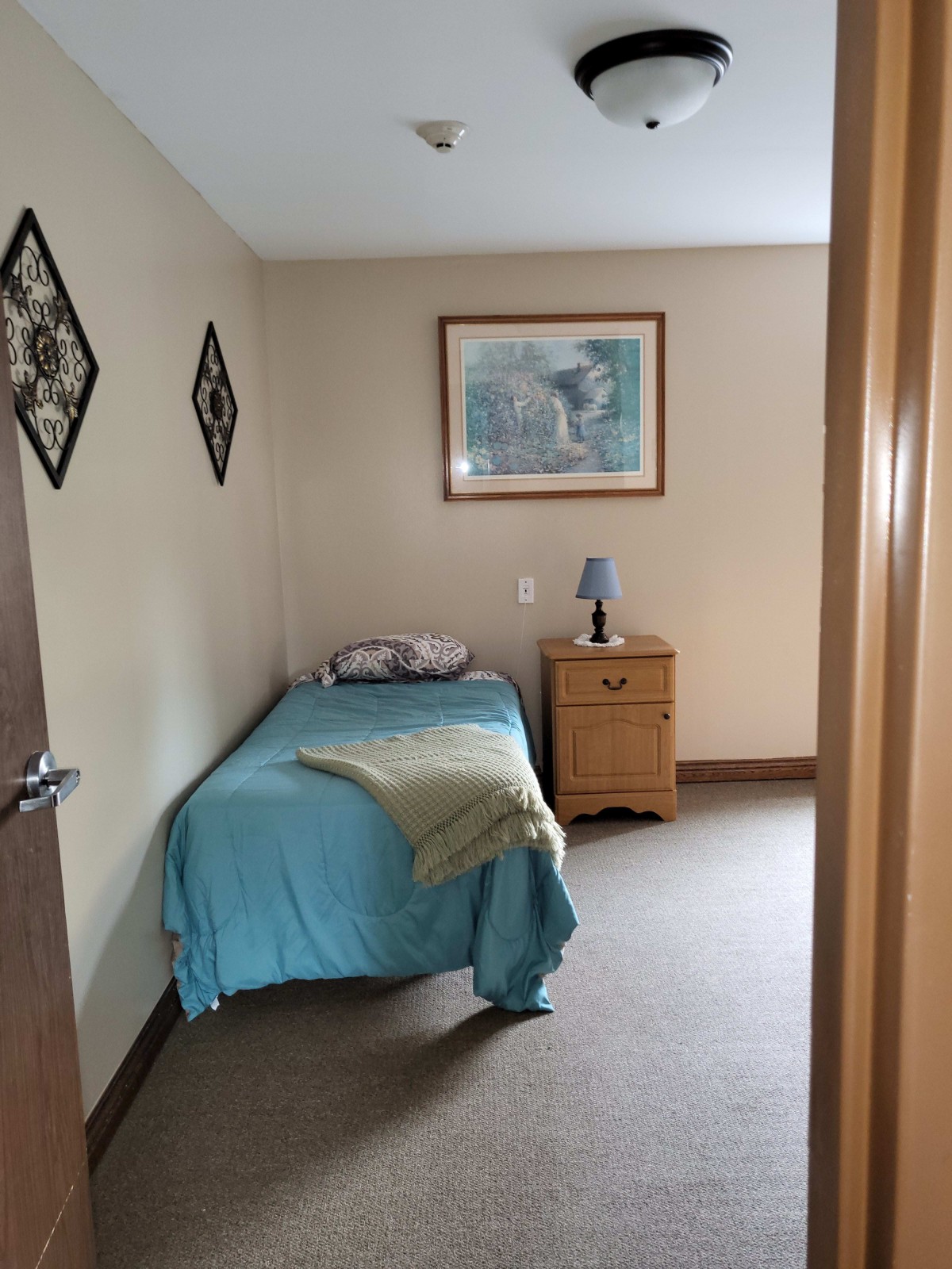 A minimalist bedroom with a single bed, nightstand, and decor.