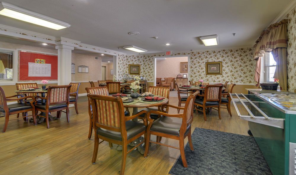 A cozy dining area featuring wooden tables and chairs with decorative wallpaper.