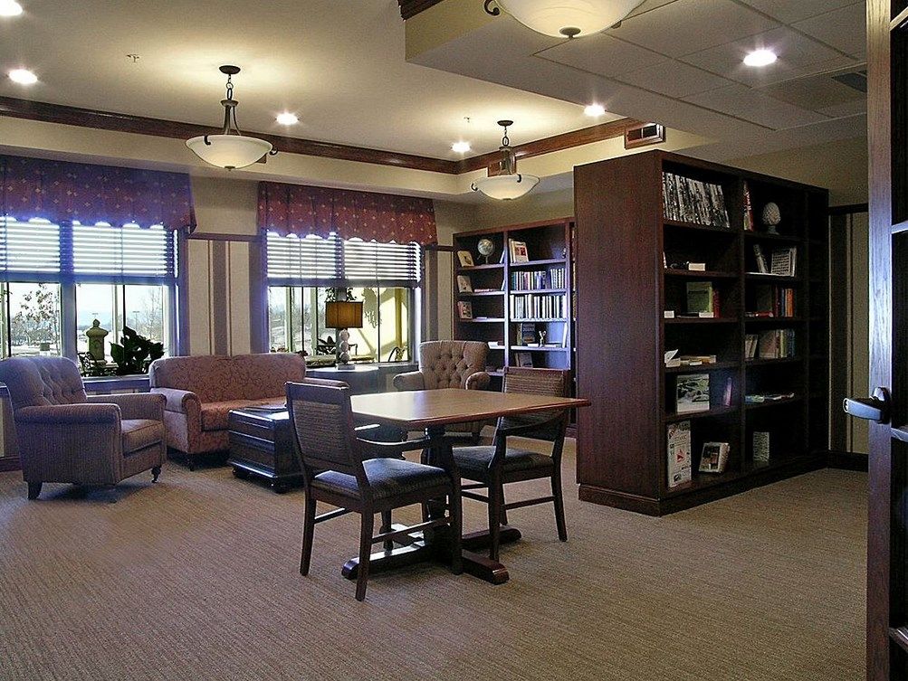 A cozy library interior with shelves of books and comfortable seating.