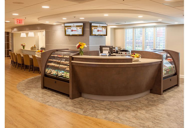 A modern cafe interior with a central counter and seating area.