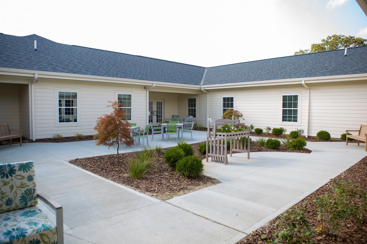 A modern building with a landscaped courtyard and sidewalk.