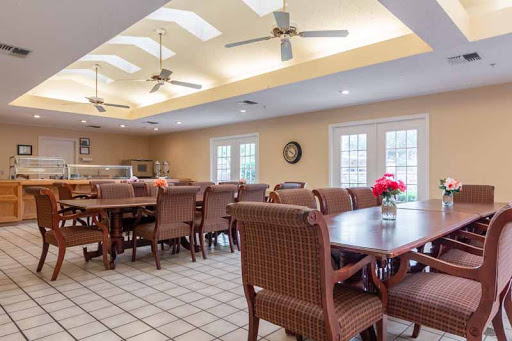 A spacious and inviting dining area featuring wooden tables, comfortable chairs, and ceiling fans for a relaxed atmosphere.