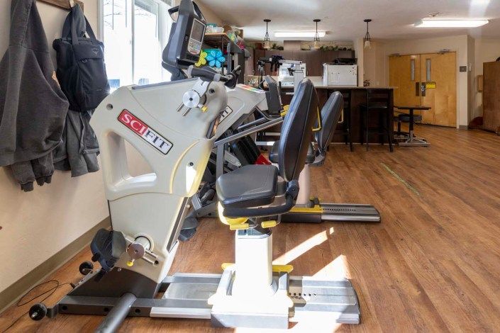 A well-equipped gym with various exercise machines lined up in a spacious room.