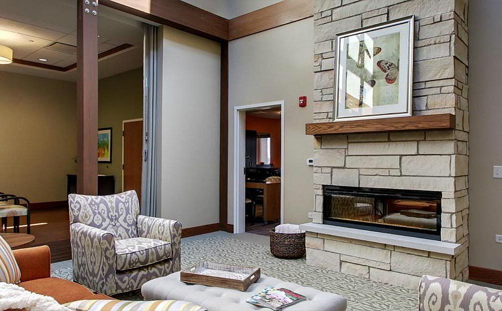 A cozy, modern living room featuring a stylish fireplace and comfortable seating.